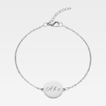Armband med gravyr. Silverfärgad armband med bricka