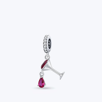 Hängande berlock i 925 sterling silver formad som ett cocktailglas med djupröd zirkoniakristall och en hängande röd droppe, fäst vid en ögla med klara glittrande stenar mot en vit bakgrund.