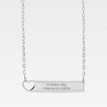 Silverfärgad halsband med rektangulär hänge med gravyr.