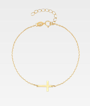 Armband med kors i guldpläterat sterling silver på vit bakgrund
